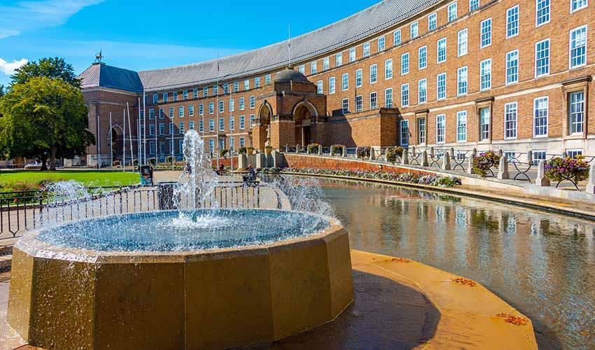 General view of City Hall in Bristol, showing a large curved building of five storeys with a fountain in the foreground