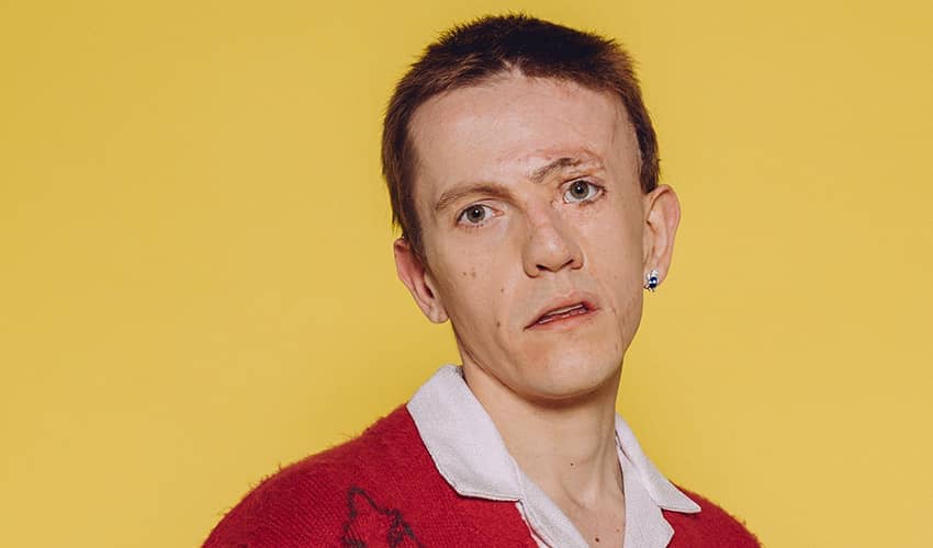 Actor Robert Rhodes looking at the camera, with a yellow background