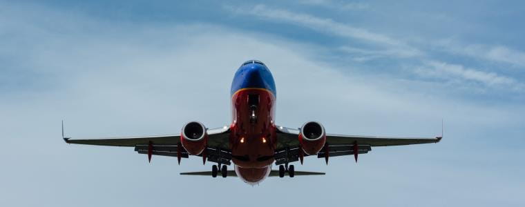 Silhouette of a large passenger airplane climbing in the sky.