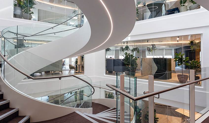 The interior of Osbourne Clarke's offices, an open spiral staircase leading to open plan offices