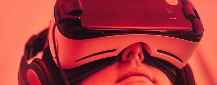 Stylised close up of person wearing a VR headset with red filter across whole image.