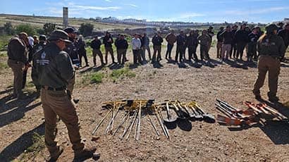 A image of people searching for graves in Mexico, with spades and other tools on the ground
