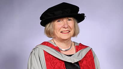 Head and shoulders image of Louise Mitchell wearing a black cap and red graduation ceremony robes