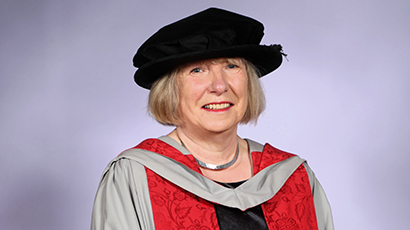 Head and shoulders image of Louise Mitchell wearing a black cap and red graduation ceremony robes