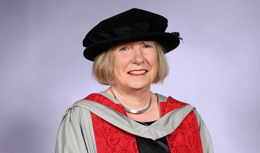 Head and shoulders image of Louise Mitchell wearing a black cap and red graduation ceremony robes