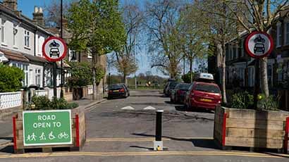 Street of terraced houses with a modal filter stopping cars but allowing pedestrians and cyclists to enter