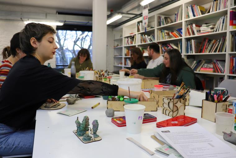 People sitting at a table participating in a creative workshop.