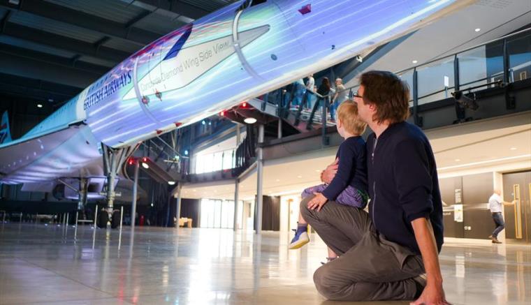 Dad and son looking at an aircraft in an aerospace museum.