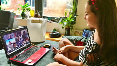 A young girl attending an online class via her laptop