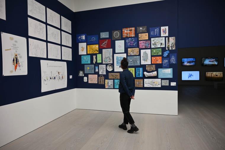 A person looking at artworks in an exhibition room
