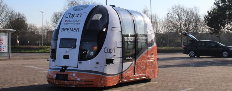 An autonomous bus driving around the car park