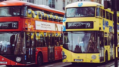 A red and a yellow bus