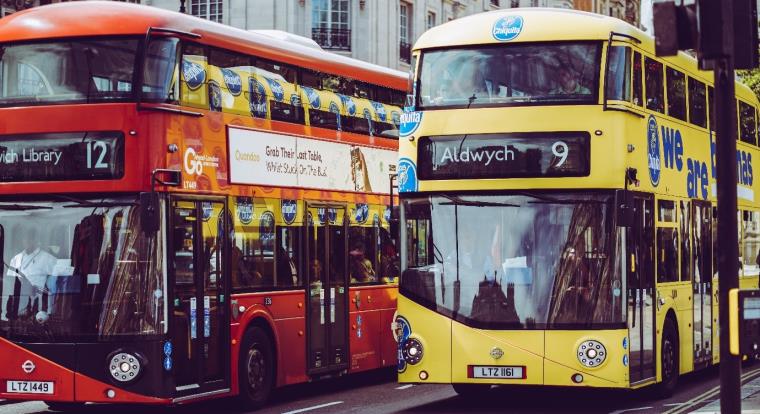 A red and a yellow bus