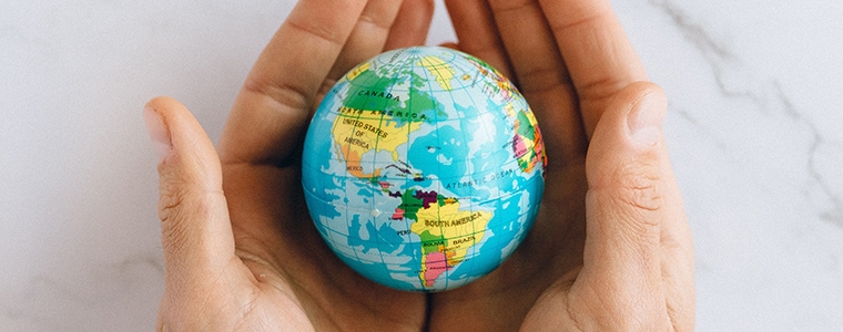 Human hands holding the globe