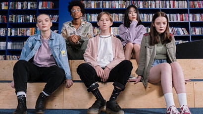 A group of teenagers sitting in the library 