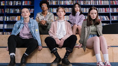 A group of teenagers sitting in the library