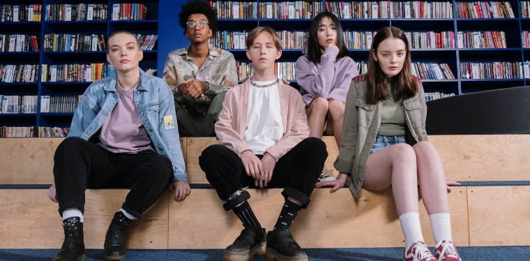 A group of teenagers sitting in the library