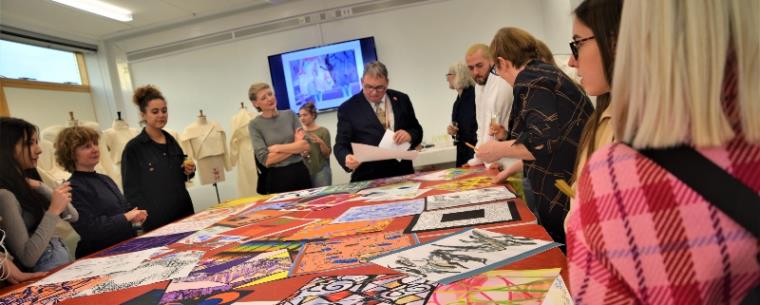 A group of people are looking at drawing designs and discussing