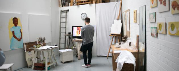 A man looking at an artwork in an art workshop
