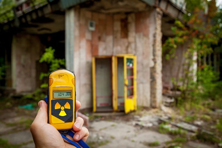 A person measuring the amount of radioactive material in an abandoned area