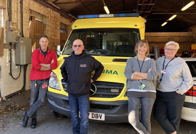 Four UWE staff standing in front of an ambulance