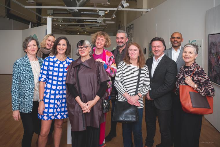 A picture of artists standing in the exhibition room