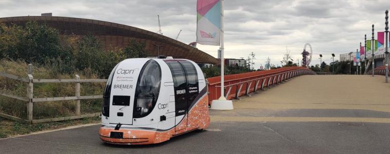 A white driverless pod on the path at the Olympic Park.