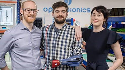Samantha Payne and Joel Gibbard standing with man wearing bionic arm.
