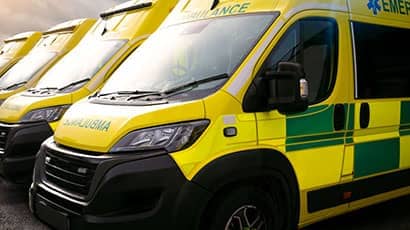 A line of parked yellow ambulances