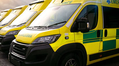 A line of parked yellow ambulances