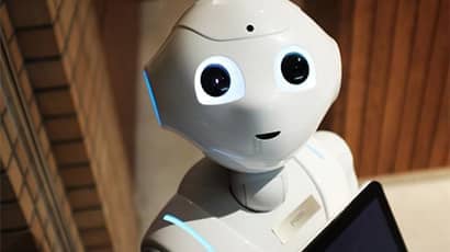 New socially assistive robot wearing name tag and holding an ipad.