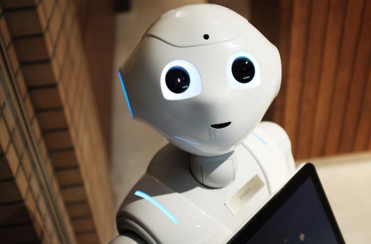 New socially assistive robot wearing name tag and holding an ipad.