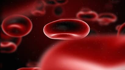 Computer illustration of blood cell against dark red background