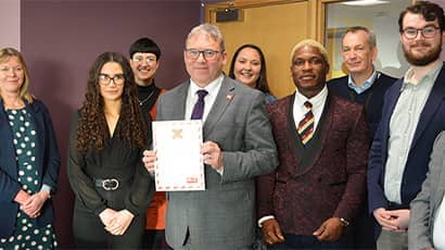 Steve West holding signed pledge alongside other UWE Bristol staff.