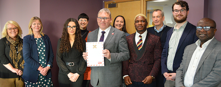 Steve West holding signed pledge alongside other UWE Bristol staff.