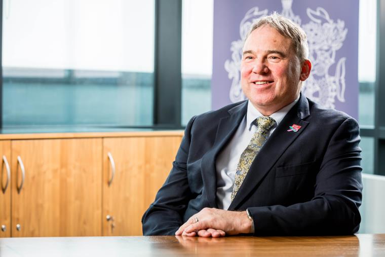 Professor Steve West sat at a table smiling.