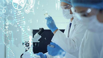Two people in while lab clothing and face masks working with a flask, a syringe and a microscope.