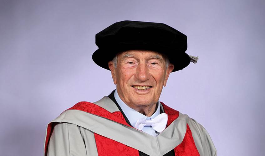 Robert Channon, wearing a black cap and red graduation ceremony robes