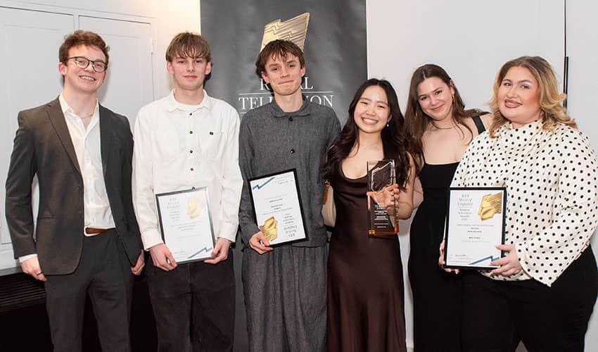 Six men and women looking at the camera and smiling, with several holding prizes in their hands. 
