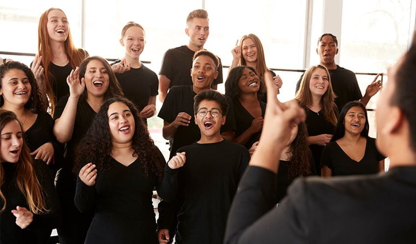 A choir, dressed in black, singing