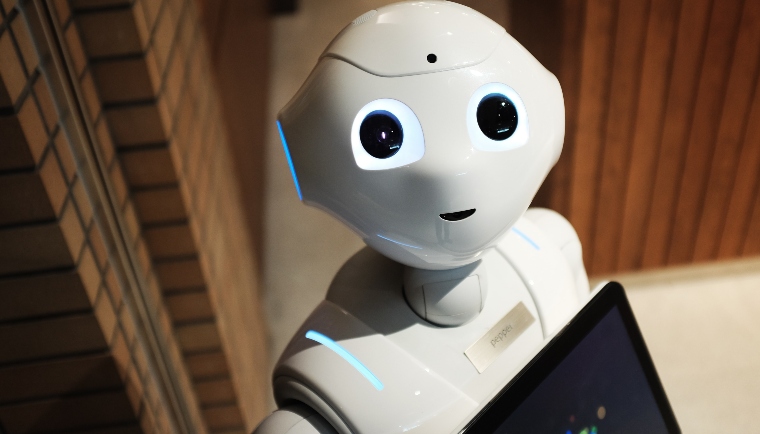 White robot with a cute face looking to camera.