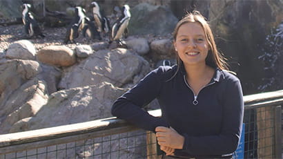 UWE Bristol student Christa Emmett standing next to the Seal and Penguin Coasts exhibit at Bristol Zoo Gardens.