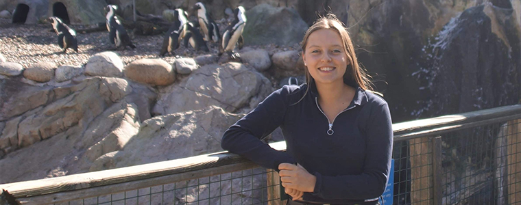 UWE Bristol student Christa Emmett standing next to the Seal and Penguin Coasts exhibit at Bristol Zoo Gardens.