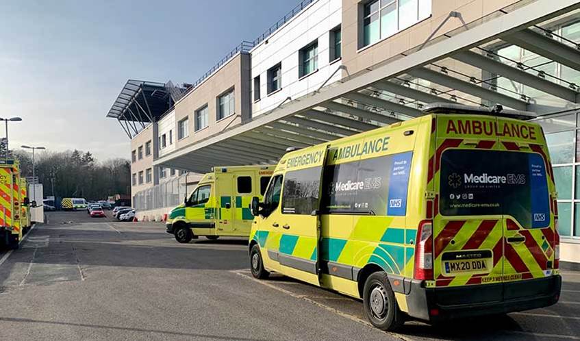 Several ambulances parked outside of a hospital