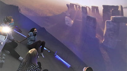 Guests seated on the floor in the Hub watching the planetarium show projected onto the dome-shaped walls.