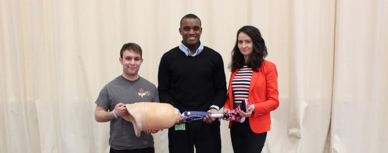 Dr Etoundi, Mike Rose and Mayur Hulke together holding a prosthetic leg.