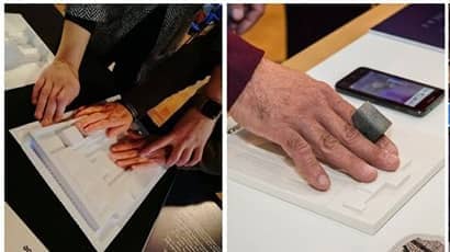 Image of visually impaired users using technology with their hands to view world  heritage sites.