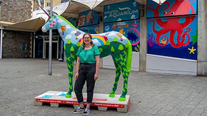 UWE Bristol's decorated unicorn at Bristol Aquarium, with artist Chloe Tyler