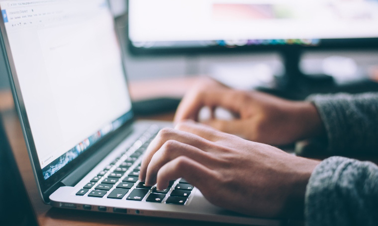 Someone typing on a laptop keyboard.