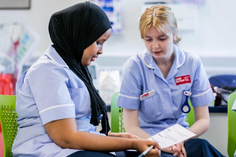 Two UWE Bristol nursing students going over paperwork together.